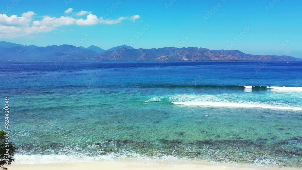 foamy waves washing beautiful sandy beach. Aerial landscape with the mountains in the background foamy waves washing beautiful sandy beach. Aerial landscape with the mountains in the background