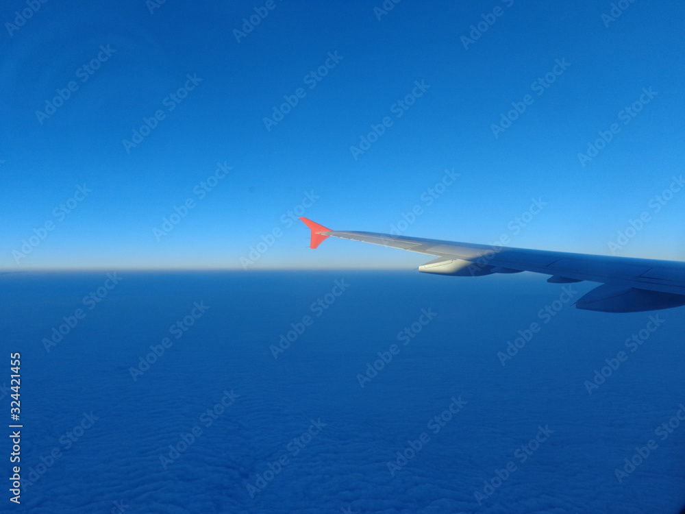 flying in a plane in the sky above the clouds on the wing at dawn aviation vacation flying in a plane in the sky above the clouds on the wing at dawn aviation vacation