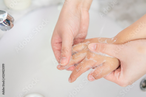 Young asian woman washing hands for her son