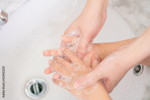 Young asian woman washing hands for her son