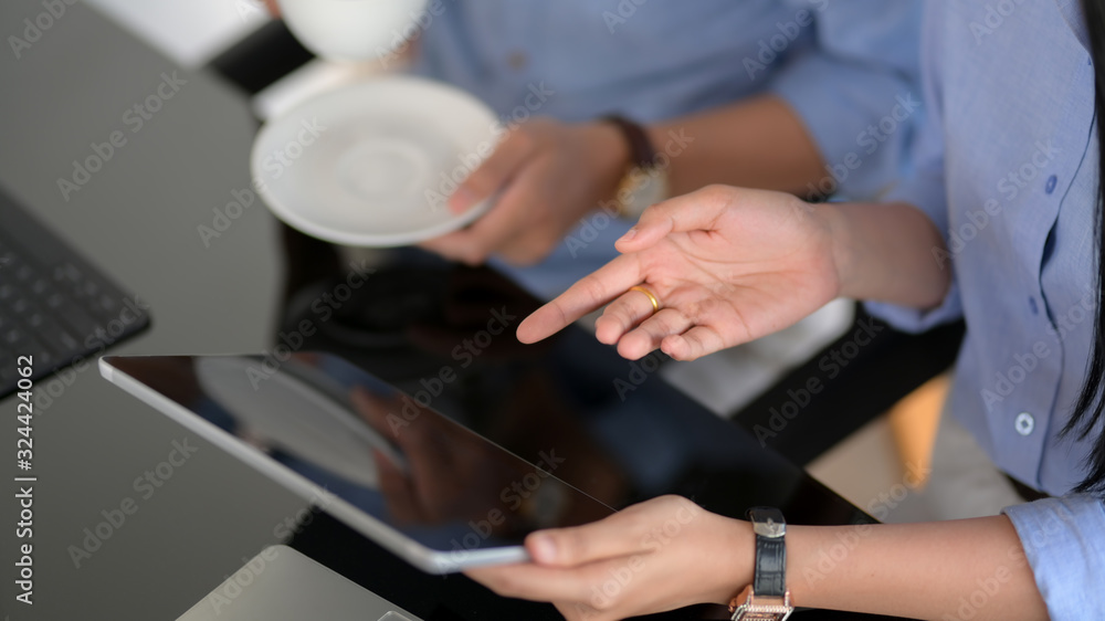 Cropped shot of businesspeople consulting on their project with digital tablet