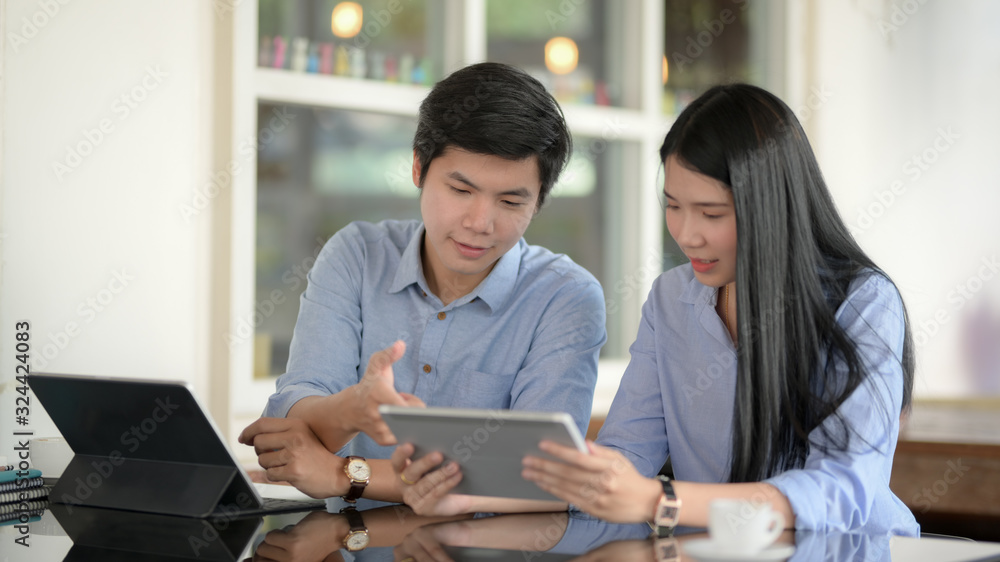 Obraz premium Cropped shot of businesspeople discussing on their project with digital tablets