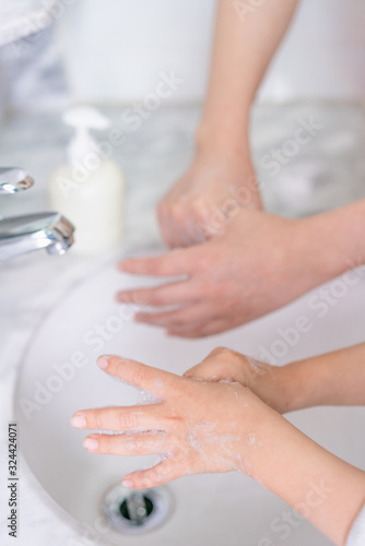 Young asian woman washing hands for her son