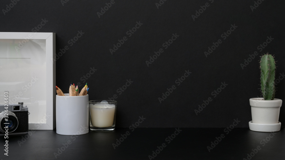 Close up view of dark modern workplace with mock up frame on black table Close up view of dark modern workplace with mock up frame on black table