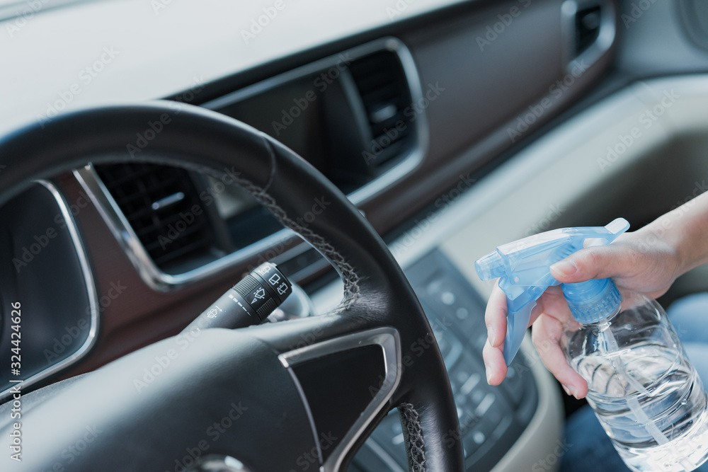 Asian women disinfect and clean car interior Asian women disinfect and clean car interior