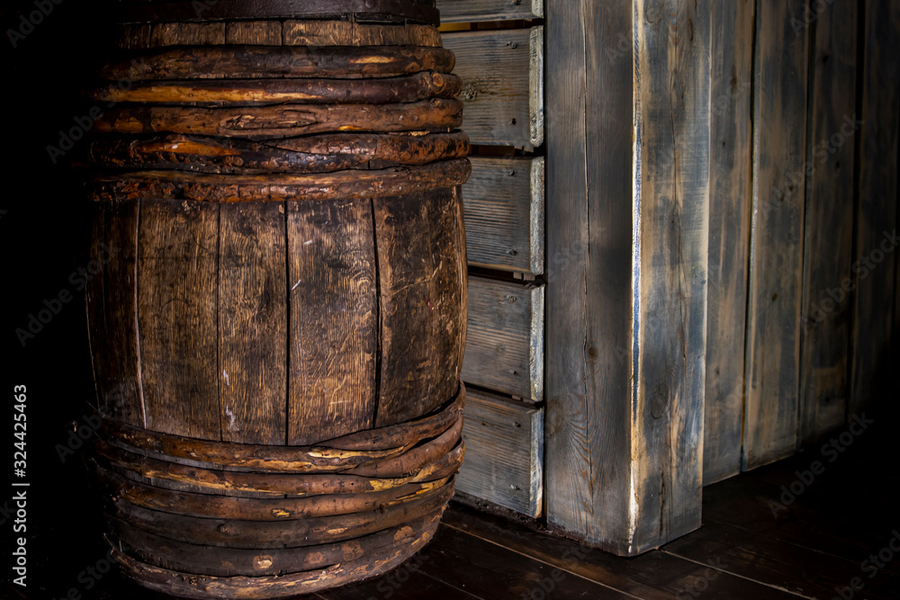 Wooden wine barrel in the basement against the wall. Wooden wine barrel in the basement against the wall.