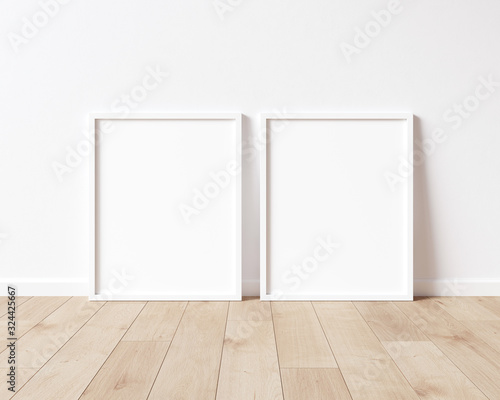 Fototapeta Naklejka Na Ścianę i Meble -  Two vertical white frame mock up on wooden floor with white wall. 3D illustrations.