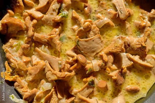 Chanterelle mushrooms are stewed in sour cream in a deep pan.