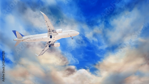 A white passenger plane that has just taken off against a background of beautiful and dramatic clouds. Extended landing gear