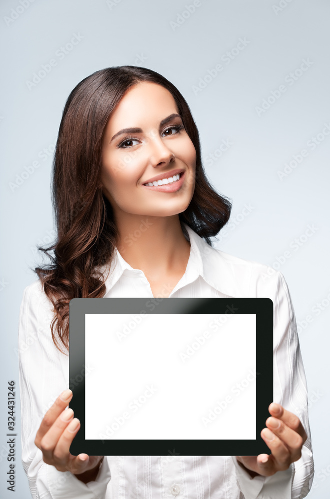 Business woman showing blank tablet pc, on grey Business woman showing blank tablet pc, on grey