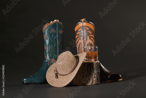 Принти на полотні Green and Tan Cowboy Boots, Whiskey and Cowboy Hat on a Tree Stu