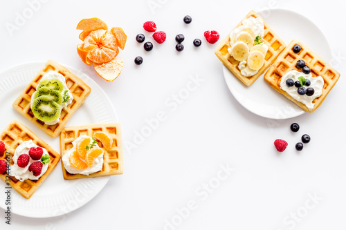 Breakfast with freashly baked belgian waffles on white background top-down frame copy space photo