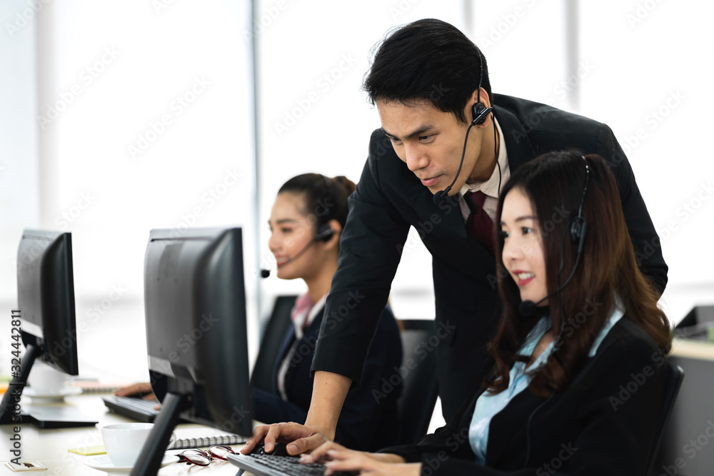 Group of happy smiling business operator customer support team phone services working with headset and computer at call center