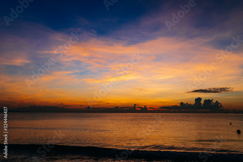 Sunrise, sunset of the sun through the clouds, tropical area near  sea. © Максим Ирха