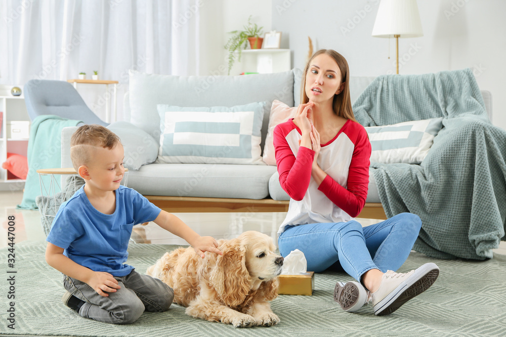 Cute little boy with dog and his mother suffering from pet allergy at home Cute little boy with dog and his mother suffering from pet allergy at home