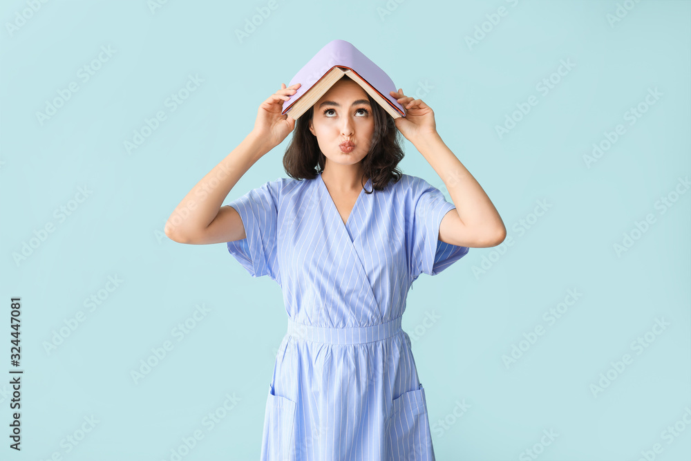 Cute young woman with book on color background Cute young woman with book on color background