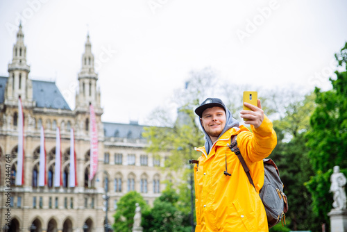 tourist traveler man taking selfie on phone vienna city hall on background