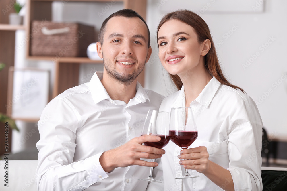 Happy young couple drinking wine on romantic date at home Happy young couple drinking wine on romantic date at home