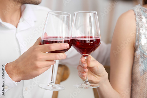 Happy young couple drinking wine on romantic date in cafe, closeup © Pixel-Shot