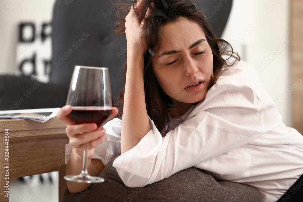 Woman drinking wine at home. Concept of alcoholism Woman drinking wine at home. Concept of alcoholism