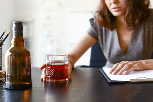 Young drunk woman in office. Concept of alcoholism photo