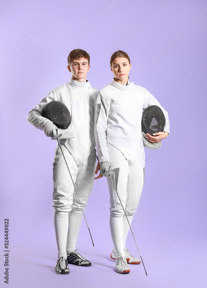 Fototapeta premium Young fencers on color background