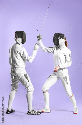 Young fencers on color background