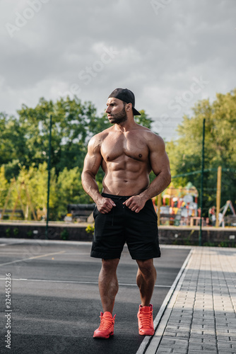 Sexy fitness sportsman posing on a sports field topless. Fitness, bodybuilding, healthy lifestyle