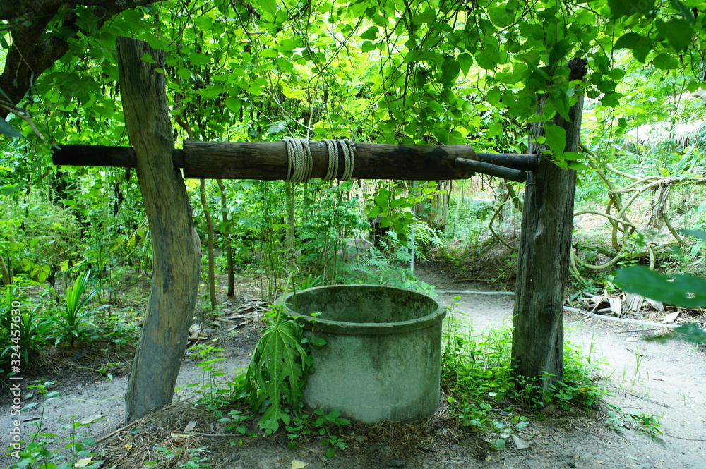 Wooden logs with rope on top of well for underground water