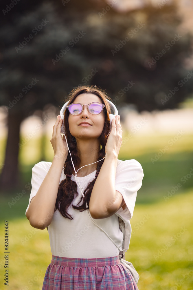 Woman With Headphones Outdoors in the City Park