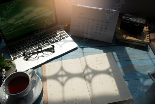 Planner and Calendar Concept.Desktop Calendar 2020,diary,smartphone and eyeglasses placed on office desk.Notebook for Planner to plan timetable,agenda and appointment.