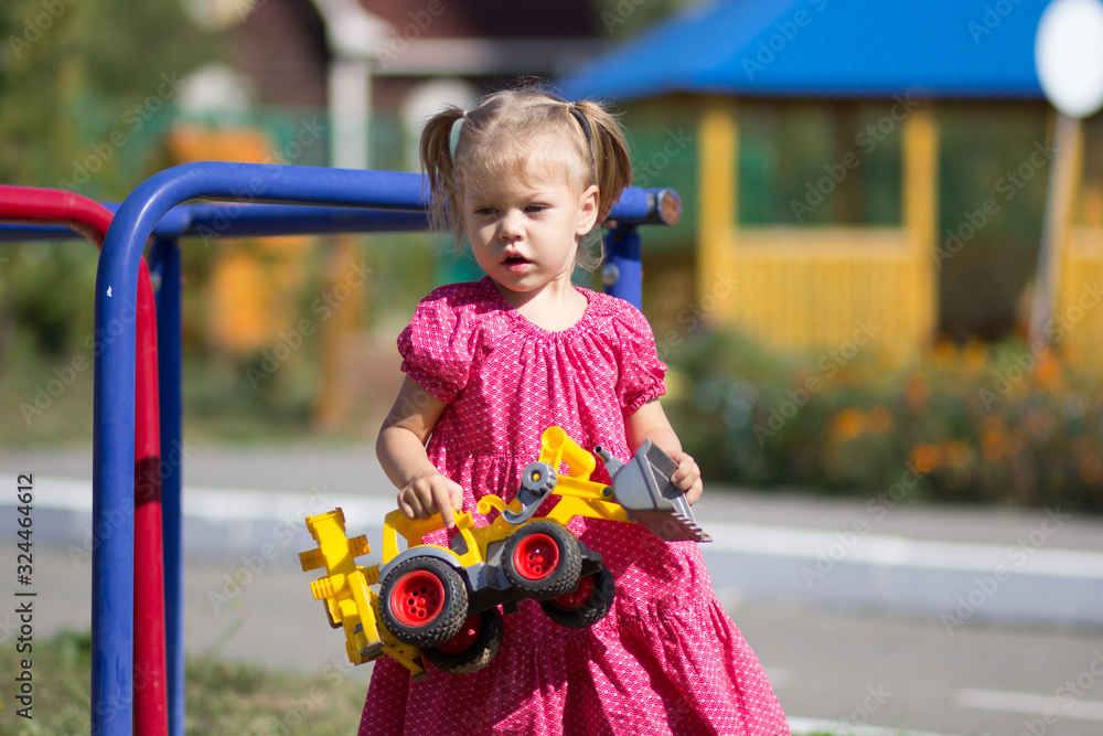 Φωτογραφία Caucasian little girl of two years old playing with toy car on playground