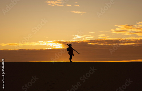 a photographer stands on sand dunes in corralejo, fuerteventura.