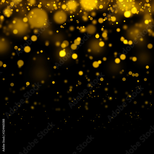 Golden light bokeh and abstract glittering on dark background. Sparkling dust particles.