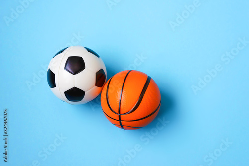 Miniature of a football and basketball on a blue background. Physical development of the child. Development center. How much does health cost 