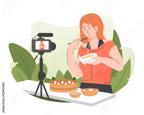 Woman food vlogger eating noodles while recording video for her online video channel. Content creator sharing online food review using camera. Food blogger concept