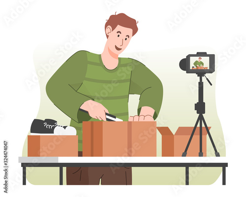 Excited male blogger unboxing cardboard package while recording video for his online video channel. Product reviewer concept