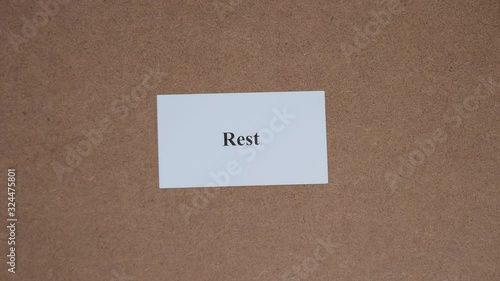 REST. Top shot - Hand puts paper card with word. CORE VALUE concept.