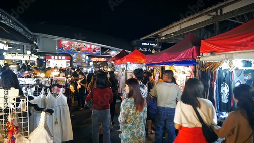 Tourist and locals walking and shopping at Rachada Night train market (Talad Rot Fai). market with plenty of shops with colorful canvas roofs at night in Bangkok