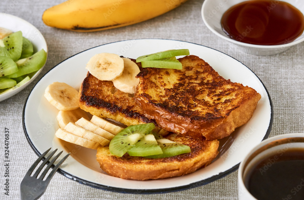 French toasts with kiwi and banana on a gray background