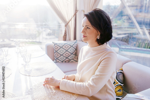 Thoughtful concept. Woman sitting at a cafe and looking afar Free Download Thoughtful concept. Woman sitting at a cafe and looking afar - GFXLoad