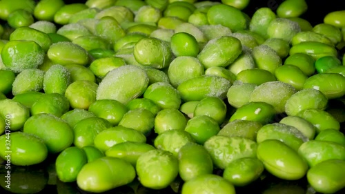 Macro dolly shot of unfreezing soybeans on black surface in studio,timelapse photo