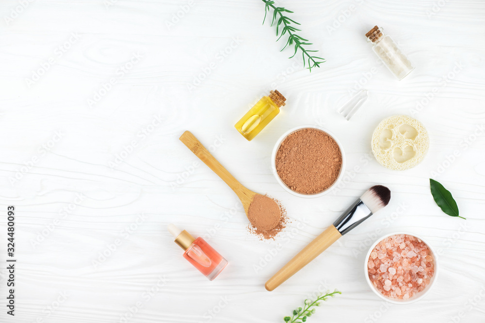 Homemade spa cosmetic set with salt, clay mask and oil on white wooden background. Copy space. Flat lay style. Homemade spa cosmetic set with salt, clay mask and oil on white wooden background. Copy space. Flat lay style.