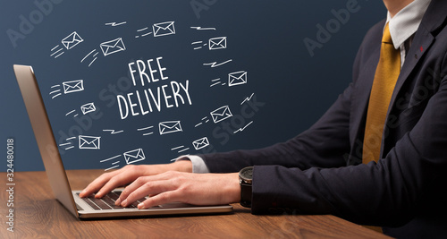 Businessman working on laptop with FREE DELIVERY inscription, online shopping concept