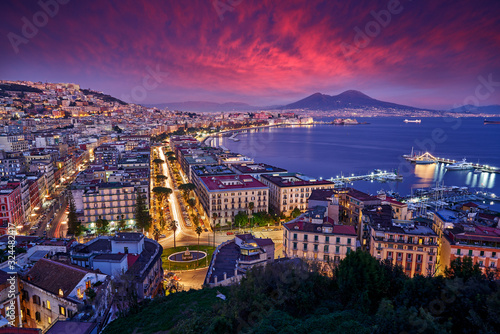Naples, twilight evening pink violet sunset. Town Napoli in Italy, travelling in the Europe. Urban landscape with city, sea, hills and Vesuvio Volcano. Beautiful sunset sky, end of the day.