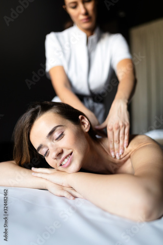 Masseur doing massage on female body in the spa salon. Beauty treatment concept.