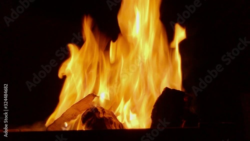 Burning firewood in a fire on dark background