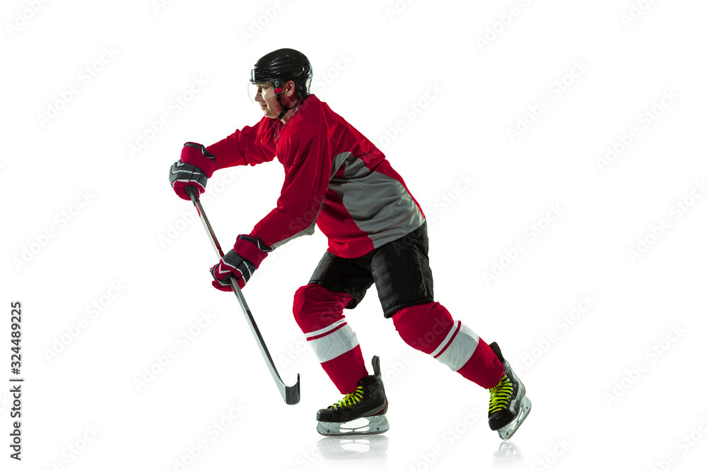 Fototapeta premium Scoring a goal. Male hockey player with the stick on ice court and white background. Sportsman wearing equipment and helmet practicing. Concept of sport, healthy lifestyle, motion, movement, action.