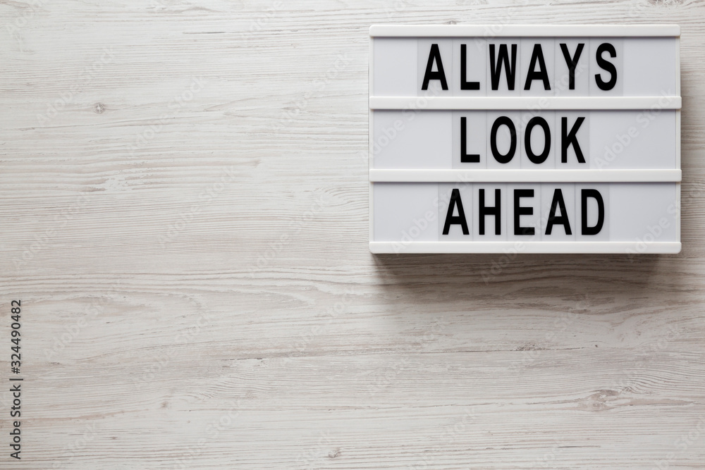 'Always look ahead' words on a lightbox on a white wooden background, top view. Overhead, from above, flat lay. Copy space. 'Always look ahead' words on a lightbox on a white wooden background, top view. Overhead, from above, flat lay. Copy space.