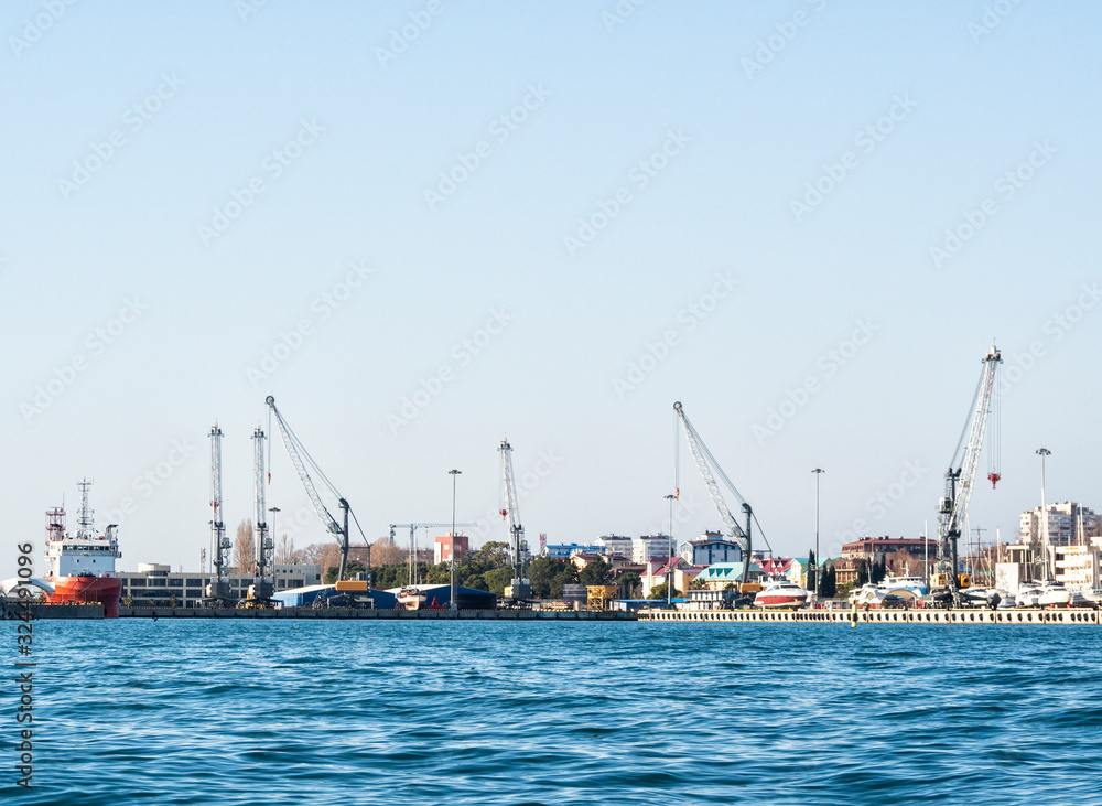 Panoramic view of sea port with loading cranes and ships